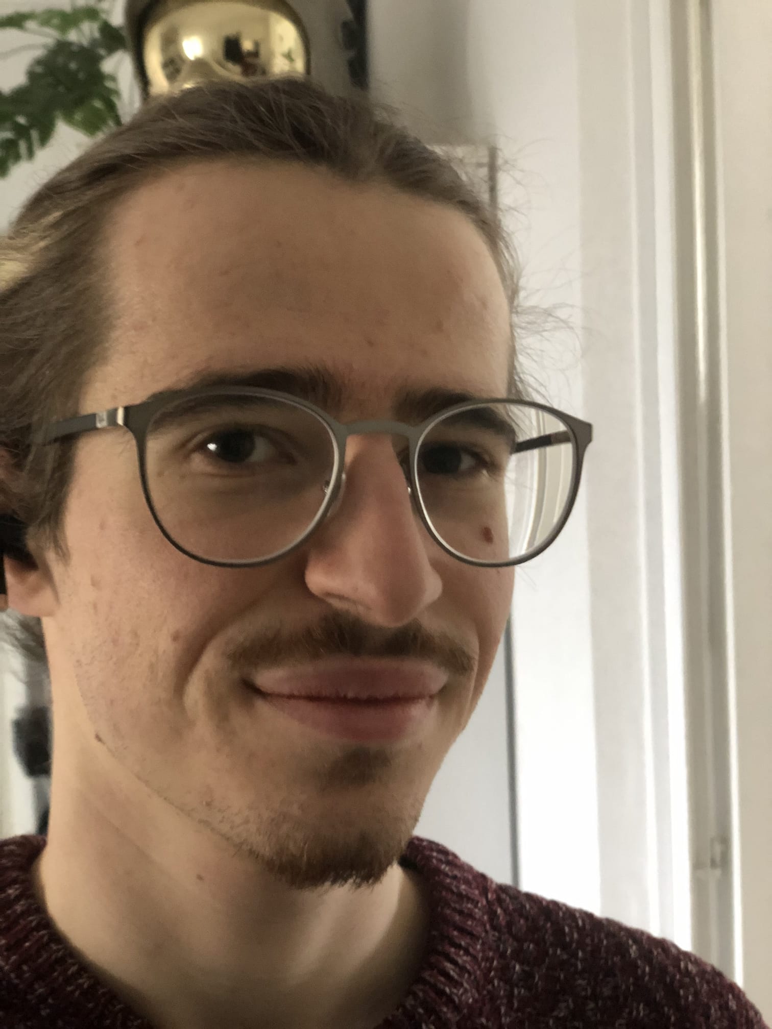 Ugo Martinez, PhD student in physics, smiling in an indoor environment